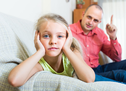 Serious father 30s rebuking small daughter for offence at home