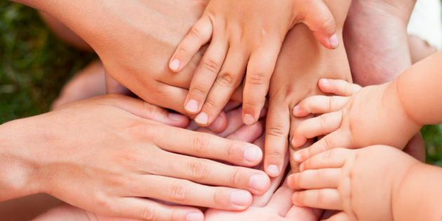 Family holding hands together closeup